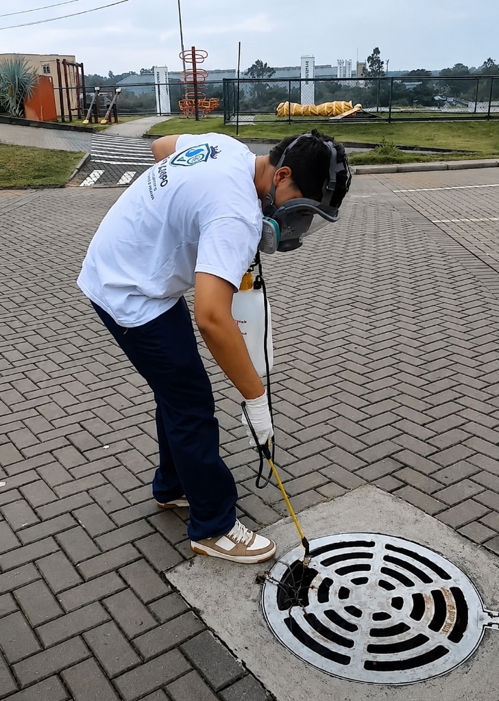 Profissional com EPI realizando sanitização de ambientes